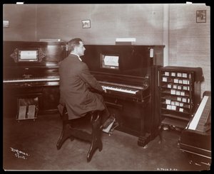 Een man die een pianola bespeelt in een pianowinkel in New York, 1907